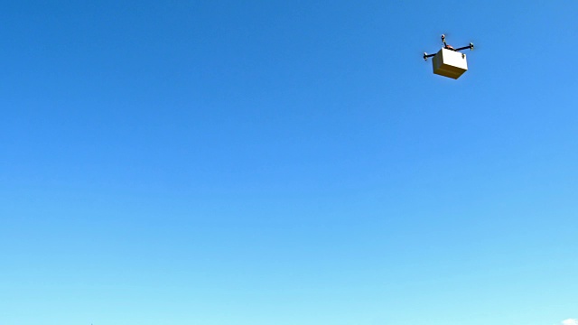 LD无人机载着一个盒子飞过天空视频素材