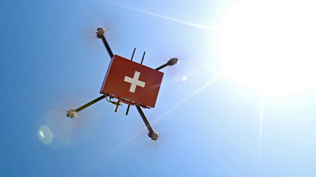 无人机载着急救箱飞过晴朗的天空视频素材
