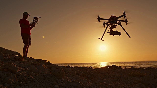 日落时分，一名警长操控一架从海滩起飞的无人机视频素材