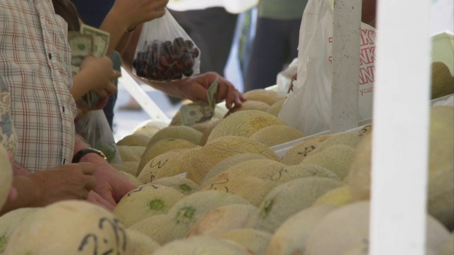 人们在农贸市场挑选哈密瓜的特写。视频下载
