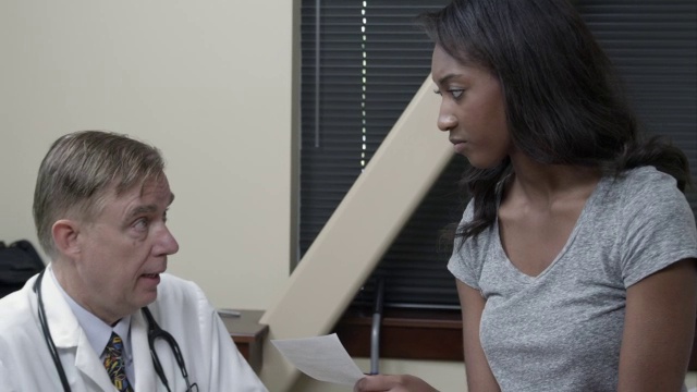 医生与年轻女子讨论处方。视频素材