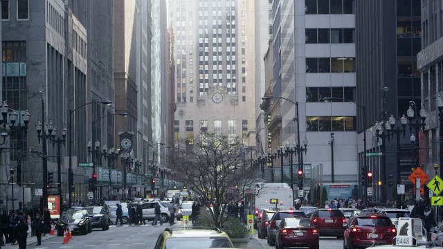 在芝加哥市中心的一个十字路口，车辆停了下来。相机倾斜的摩天大楼。视频素材