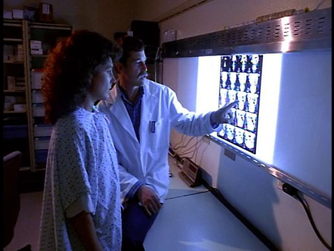 中镜头摄影拍摄男医生向女病人解释x光视频素材
