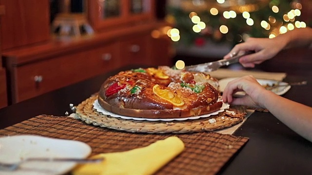 甜蜜的圣诞节。女孩切了一块水果蛋糕，端上餐桌。视频素材