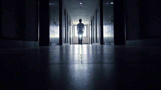 男人走在黑色的走廊里视频素材