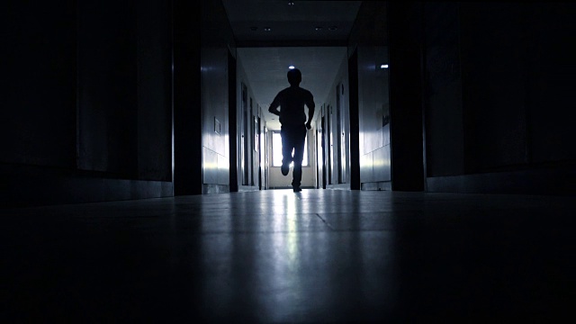 在黑色走廊里奔跑的男人视频素材
