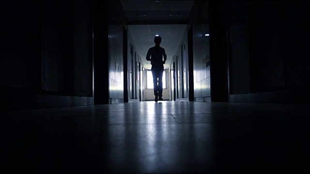 在黑色走廊里奔跑的男人视频素材