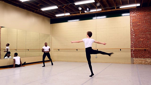 MS男芭蕾舞者热身，而同学伸展练习前在舞蹈工作室视频素材