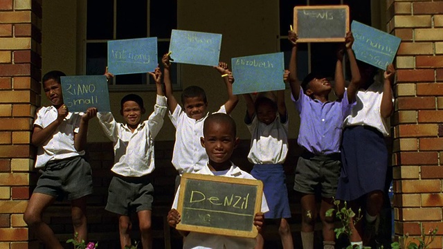 在南非户外，黑人男孩和女孩举着写有名字的黑板视频素材