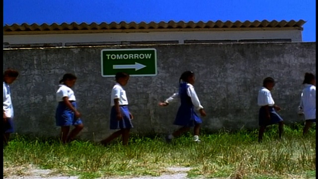 一群黑人小学生走过写着“明天”的牌子/南非视频素材
