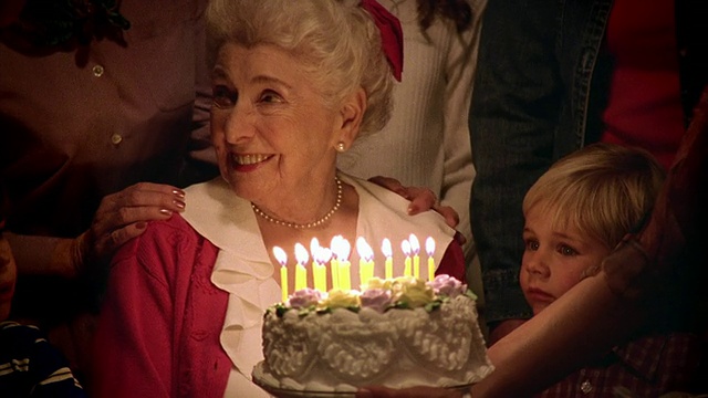 在室内家人的簇拥下，中焦生日蛋糕被摆在一位年长女士面前视频购买