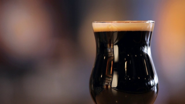 黑色烈性啤酒，装在一个大郁金香杯里视频素材