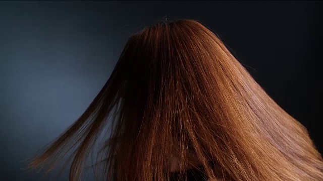 漂亮的红发女孩甩着她的长发视频素材