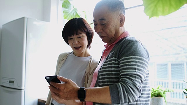 日本老人向妻子展示智能手机视频购买