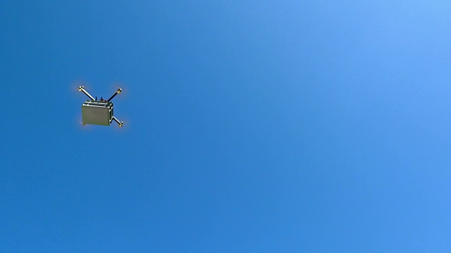 无人机在晴朗的天空中运送包裹视频素材