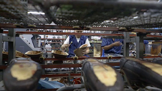 在鞋厂工作的操作人员的平移视图视频下载