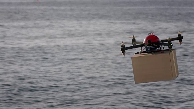 SLO MO无人机在阳光下在海面上运输包裹视频素材