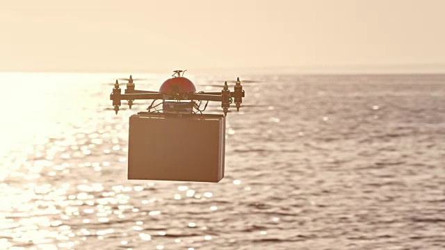 SLO MO无人机在阳光下海面上运送包裹视频素材