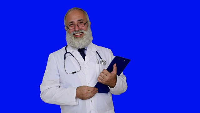 成年医生在蓝色背景的写字板上写字。视频下载