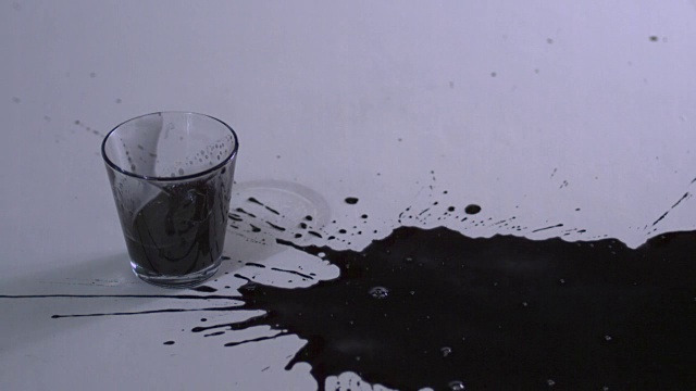 这是一个装满黑色墨水的玻璃杯掉落的镜头视频素材