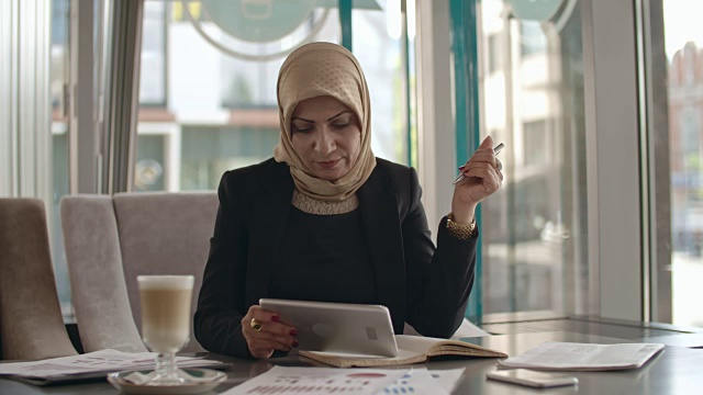穆斯林女商人在咖啡馆里使用平板电脑视频素材