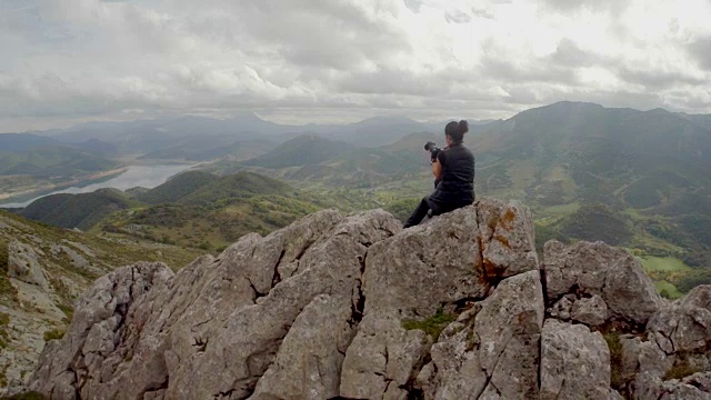 一个女人在山上拍照的鸟瞰图视频素材