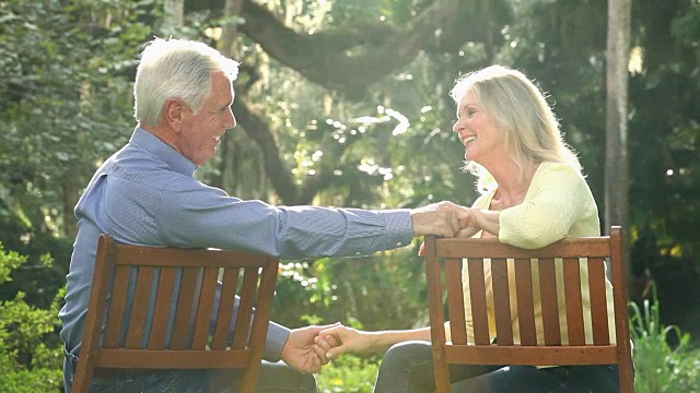 老夫妇在公园见面，坐下来聊天视频素材
