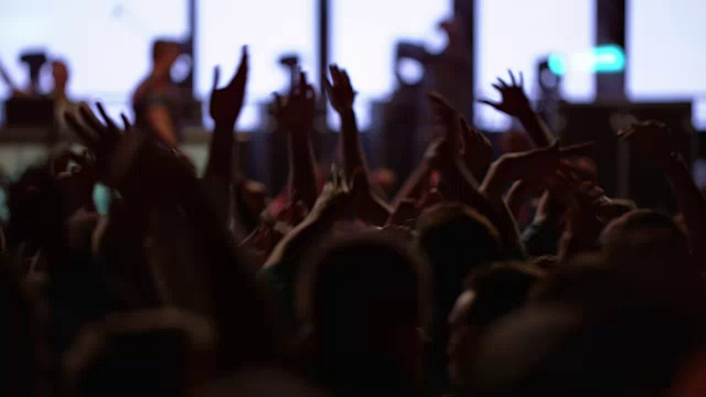 观众在晚间音乐会上举起手跳来跳去视频素材