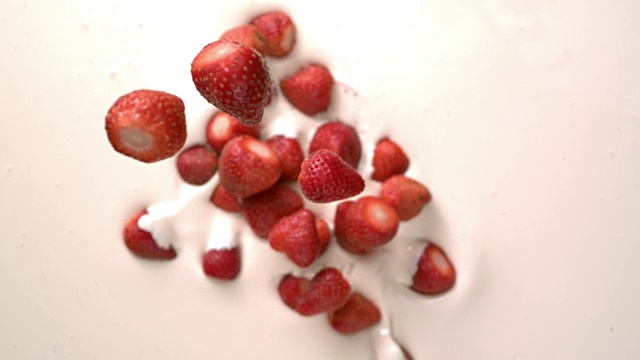 草莓落在白色酸奶奶油上的慢动作桌面视频下载