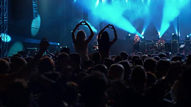 两个女人在音乐会上用手做心形视频素材
