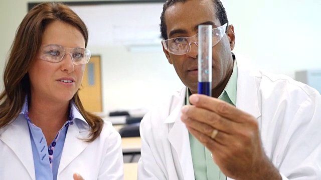 男性和女性科学家在试管中分析液体视频下载