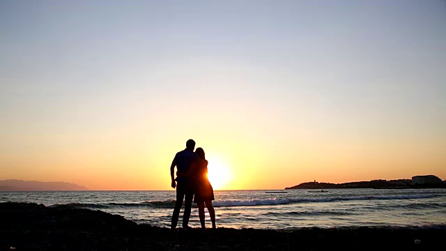 日落时分，一对情侣在海滩上拥抱视频下载