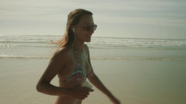 穿着比基尼的美女在法国南部的大西洋海滩上散步、跳舞、听音乐视频下载