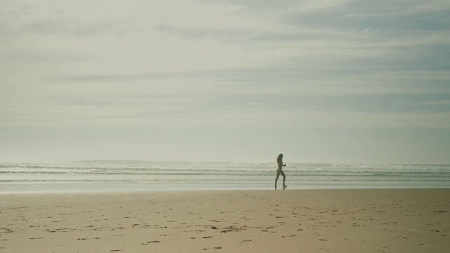 穿着比基尼的美女沿着法国南部荒芜的大西洋海滩散步视频下载