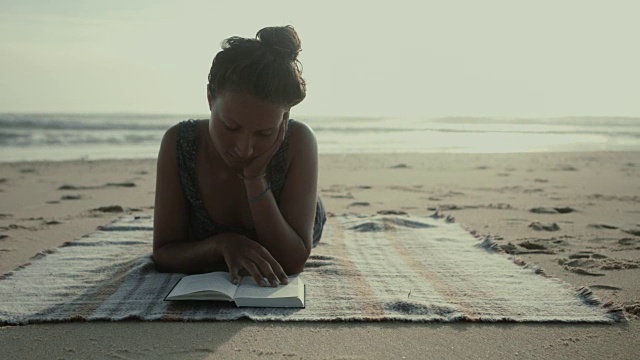在法国南部大西洋的海滩上，躺在毯子上的美丽女人视频下载