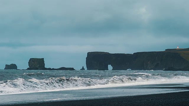 从冰岛南部的Reynisfjara黑沙滩上看到的Dyrholaeyjarviti海拱视频素材