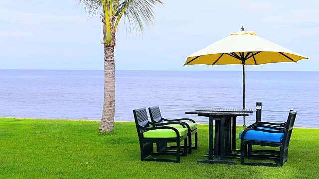海边的草地上有黄色的沙滩伞和椅子视频素材