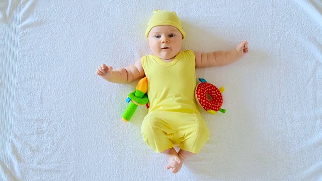 快乐的宝宝在黄色的微笑和玩耍视频下载