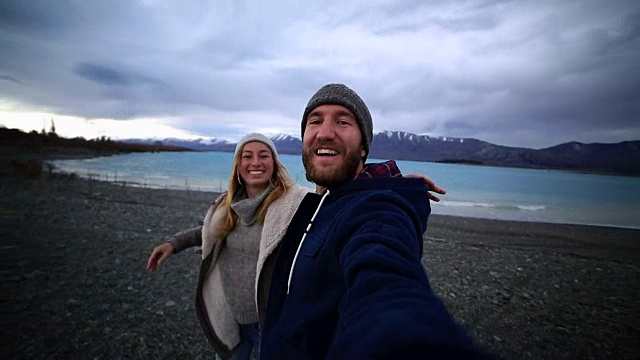一对年轻夫妇在新西兰的湖岸自拍视频下载