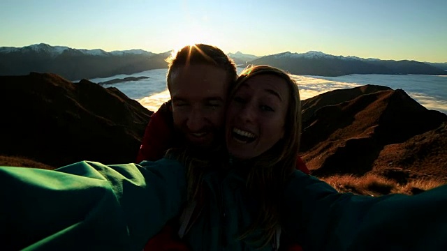 一对快乐的年轻夫妇在山顶自拍视频素材