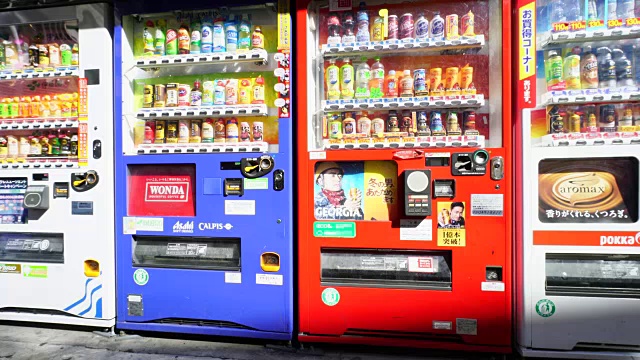 摄像头捕捉到成排的饮料自动售货机。在右侧可以看到成人软件商店的招牌。视频下载