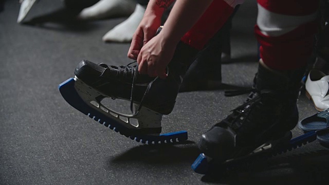 女子冰球运动员在练习前系溜冰鞋的手视频素材