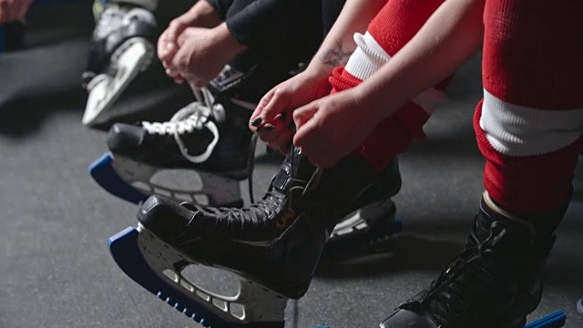 女子冰球队在练习前系溜冰鞋视频素材