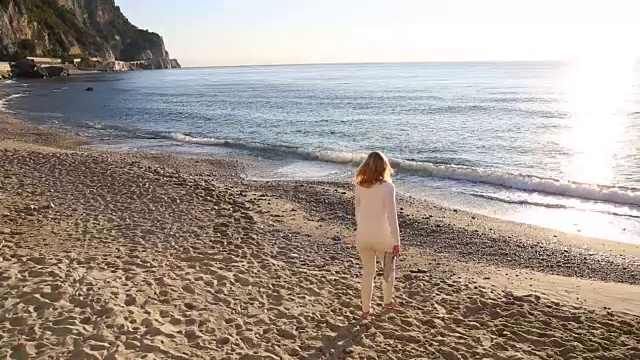 女人走过海滩，浪边，海视频素材