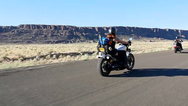 在夏天的晚上，女性朋友骑摩托车穿越沙漠视频下载
