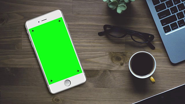 白色智能手机在桌上与色度键绿色屏幕视频素材
