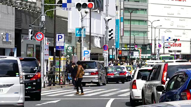 东京toshimaku Meiji-Dori ikebukuo站东入口前的摄像头捕捉到了行人和城市交通。视频素材