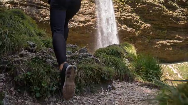 一个女人跑向瀑布，在瀑布前停了下来视频素材