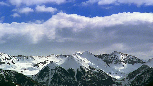 宽镜头延时白色蓬松的云在蓝天之上的雪山/洛基山脉附近特柳赖德，科罗拉多州视频素材