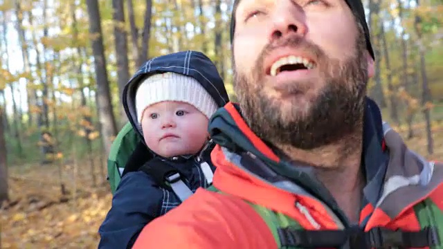 父亲和宝宝在秋天森林徒步旅行视频素材